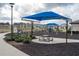 Community playground with picnic tables, swings, and climbing structures shaded by a blue canopy at 6367 Sw 70Th Cir, Ocala, FL 34474