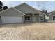 Charming single-story home features a wide two-car garage and covered entry, all with a neutral gray color scheme at 6644 Sw 179Th Avenue Rd, Dunnellon, FL 34432