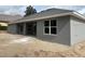 Exterior shot of the house highlighting the neutral stucco and backyard at 6698 Sw 179Th Avenue Rd, Dunnellon, FL 34432