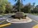 Community entrance sign with lush landscaping along a paved road in Juliette Falls at 6698 Sw 179Th Avenue Rd, Dunnellon, FL 34432