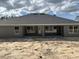 Gray single story home with a dark roof and unfinished backyard at 6943 Sw 179Th Court Rd, Dunnellon, FL 34432