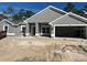 Gray single Gathering home with an attached two car garage and unfinished front yard at 6943 Sw 179Th Court Rd, Dunnellon, FL 34432