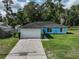 Charming blue single story home with a two car garage and a well maintained front lawn at 6950 Se 124Th Ln, Belleview, FL 34420