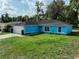 Well-manicured front yard of this charming blue single story home with attached two-car garage at 6950 Se 124Th Ln, Belleview, FL 34420