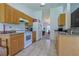 Traditional kitchen with light wood cabinetry, white appliances, and neutral tile flooring at 6950 Se 124Th Ln, Belleview, FL 34420