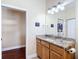 Bathroom features wood cabinets, granite counters and backsplash, and a large mirror at 7688 Se 135Th St, Summerfield, FL 34491