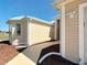 Close up exterior shot of the tan siding, sidewalk, and well manicured landscaping with rock at 7688 Se 135Th St, Summerfield, FL 34491