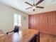 Bright office with wood flooring features built in custom storage, a desk, and ceiling fan at 7688 Se 135Th St, Summerfield, FL 34491