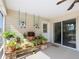 Covered patio featuring hanging swings, lush plants, ceiling fan and sliding glass doors at 7688 Se 135Th St, Summerfield, FL 34491