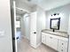 Bathroom vanity with granite countertop and a square mirror with black lighting fixture at 8295 Se 159Th Ln, Summerfield, FL 34491