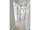 A hallway features a bedroom at the end with gray wood laminate floors and neutral paint at 8295 Se 159Th Ln, Summerfield, FL 34491