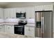 Kitchen featuring stainless steel appliances, granite countertops and white cabinetry at 8295 Se 159Th Ln, Summerfield, FL 34491