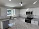 Kitchen featuring white cabinets, gray countertops, and stainless steel appliances at 8295 Se 159Th Ln, Summerfield, FL 34491