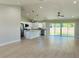 Spacious living room featuring an open kitchen, stainless appliances, granite countertops, and sliding glass doors at 8295 Se 159Th Ln, Summerfield, FL 34491