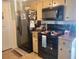 Functional kitchen featuring black appliances, including a refrigerator, microwave, and stove at 8481 Sw 107Th Pl, Ocala, FL 34481