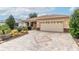 Paver driveway leading to a two-car garage, complemented by manicured landscaping and stone accents at 8532 Sw 79Th Ave, Ocala, FL 34481