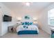 Bright main bedroom featuring a ceiling fan, a television, and a large window for natural light at 8532 Sw 79Th Ave, Ocala, FL 34481