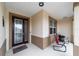 Inviting front porch with decorative door, neutral colors, and seating area for relaxing in the outdoors at 8874 Sw 104Th Cir, Ocala, FL 34481