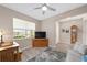 Comfortable living room features a ceiling fan, light gray walls, laminate flooring, and lots of natural light at 8874 Sw 104Th Cir, Ocala, FL 34481