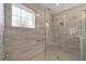 Modern shower with glass door, tiled walls, shower seat, and grab bar at 8874 Sw 104Th Cir, Ocala, FL 34481