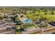 Aerial view showcasing the community pool, clubhouse, bocce ball court, and manicured landscaping at 9033 Se 136Th Loop, Summerfield, FL 34491