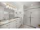 Bright bathroom featuring double sinks, a glass-enclosed shower, and tile flooring at 9033 Se 136Th Loop, Summerfield, FL 34491