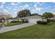 Single-story home with a lush lawn, manicured landscaping, paved driveway, and attached two car garage at 9033 Se 136Th Loop, Summerfield, FL 34491