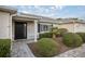 Charming front entrance features a black door, trimmed bushes, landscaped walkway, and elegant column at 9033 Se 136Th Loop, Summerfield, FL 34491