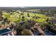 Aerial shot of a golf course with clubhouse, lush green fairways, and manicured landscaping at 9033 Se 136Th Loop, Summerfield, FL 34491