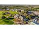 Aerial view of a golf course, showcasing the clubhouse, pool, and surrounding green spaces at 9033 Se 136Th Loop, Summerfield, FL 34491