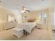 Well-lit bedroom features neutral tones, plush carpet, ceiling fan, and shuttered windows at 9126 Sw 102Nd Cir, Ocala, FL 34481