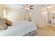 Bedroom features ceiling fan, neutral walls, carpet flooring, and an attached bathroom at 9126 Sw 102Nd Cir, Ocala, FL 34481