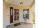 Inviting front porch featuring a decorative welcome mat, glass storm door, and exterior window at 9126 Sw 102Nd Cir, Ocala, FL 34481