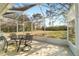 Covered patio featuring outdoor dining set and views of lush, green backyard at 9126 Sw 102Nd Cir, Ocala, FL 34481