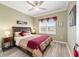 This bedroom features a ceiling fan, wood floors, and a large window at 9399 Sw 106Th Ave, Ocala, FL 34481