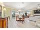 Open-concept living room with dining area, fireplace, sliding glass door, and wood-look flooring at 9399 Sw 106Th Ave, Ocala, FL 34481