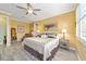 Cozy primary bedroom with a ceiling fan, neutral decor, and an ensuite bathroom at 9399 Sw 106Th Ave, Ocala, FL 34481