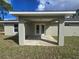 A covered back porch with double doors leading to a spacious yard creates an inviting outdoor living space at 96 Fisher Way Trl, Ocklawaha, FL 32179