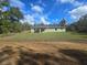 Wide backyard view of a single-story home, featuring a lush green lawn at 96 Fisher Way Trl, Ocklawaha, FL 32179