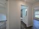 Bathroom entrance featuring a vanity with granite countertop and tiled shower at 96 Fisher Way Trl, Ocklawaha, FL 32179