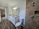 Updated bathroom featuring a double sink vanity, granite countertops, and a tiled shower at 96 Fisher Way Trl, Ocklawaha, FL 32179