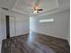 Spacious bedroom featuring modern flooring, natural light, and a tray ceiling with ceiling fan at 96 Fisher Way Trl, Ocklawaha, FL 32179