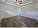 Spacious bedroom features a ceiling fan, tray ceiling, and wood-look flooring at 96 Fisher Way Trl, Ocklawaha, FL 32179