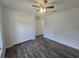 This bedroom has wood-look floors, closet doors, and a ceiling fan at 96 Fisher Way Trl, Ocklawaha, FL 32179
