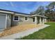 Quaint home features a covered porch, gravel landscaping, and a well manicured lawn at 96 Fisher Way Trl, Ocklawaha, FL 32179