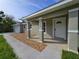 Home's front entrance featuring a covered front porch, rock landscaping, and painted pillars at 96 Fisher Way Trl, Ocklawaha, FL 32179