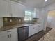 The kitchen area features updated stainless steel dishwasher, double sink and stone countertops at 96 Fisher Way Trl, Ocklawaha, FL 32179