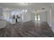Spacious living room featuring wood flooring, fan, pendant lights, and doors to the backyard at 96 Fisher Way Trl, Ocklawaha, FL 32179