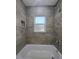 Tiled shower enclosure features a window for natural light at 96 Fisher Way Trl, Ocklawaha, FL 32179