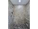 Tiled walk-in shower featuring river rock floor, built-in shelves and rainfall shower head at 96 Fisher Way Trl, Ocklawaha, FL 32179